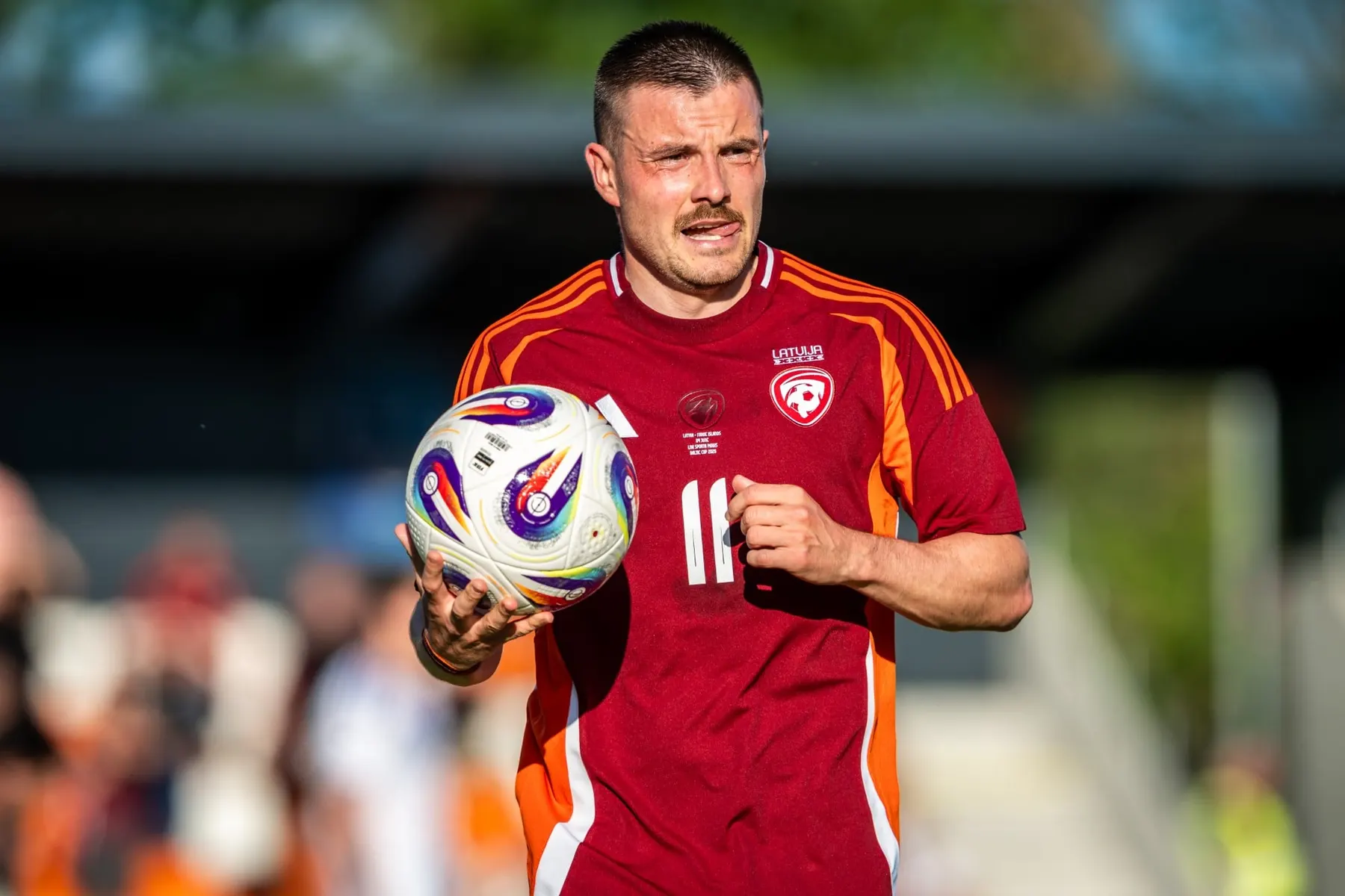 Latvijas izlases futbolists tur bumbu rokās